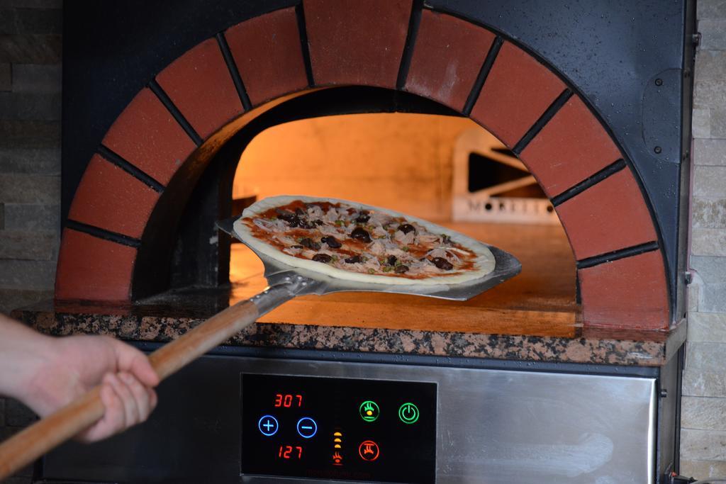 Symphony Style Hotel Kuwait Salmiya Exterior foto Pizza being removed from a wood-fired oven